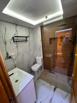 a man taking a picture of a bathroom at Appartement fes sami haut standing in Fès