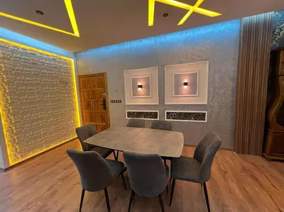 a dining room with a wooden table and chairs at Appartement fes sami haut standing in Fès