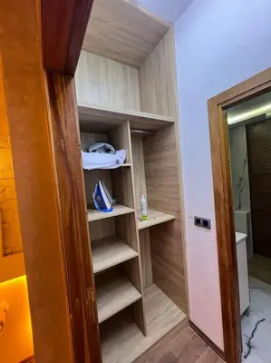 a room with a closet with shelves and a door at Appartement fes sami haut standing in Fès