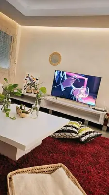 a living room with a large screen tv on a wall at Maison Ali in Ville Nouvelle