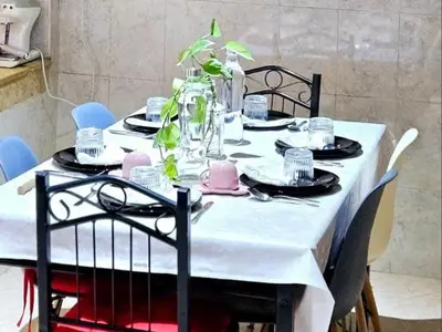 a dining room table with a white table cloth and chairs at Maison Ali in Ville Nouvelle