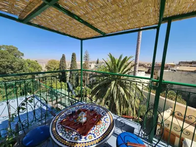 a table with a plate of food on a balcony at Dar Zerbtana suite privative in Fès al Bali