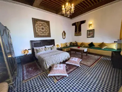 a bedroom with a bed and a couch at Dar Zerbtana suite privative in Fès al Bali