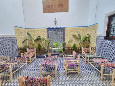 a room with chairs and tables in a room at Dar Zerbtana suite privative in Fès al Bali