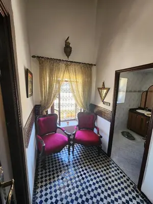 two chairs sitting in a room with a window at Dar Zerbtana suite privative in Fès al Bali