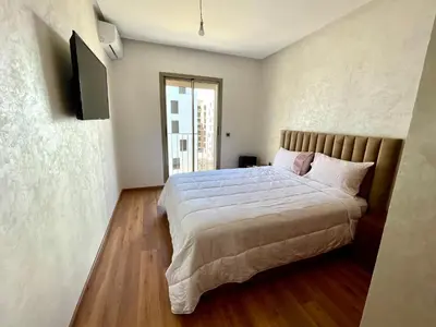a bedroom with a large bed and a television at Appartement luxueux Prestigia Wifi Fibre Optique in Fès