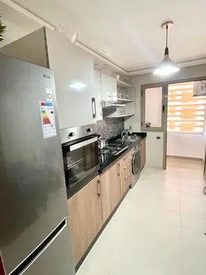 a kitchen with a refrigerator and a stove top oven at Appartement luxueux Prestigia Wifi Fibre Optique in Fès