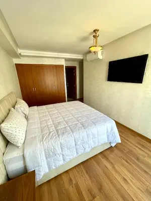 a bedroom with a bed and a flat screen tv at Appartement luxueux Prestigia Wifi Fibre Optique in Fès