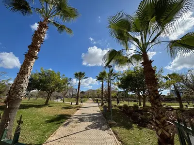 a path in a park with palm trees at Appartement luxueux Prestigia Wifi Fibre Optique in Fès