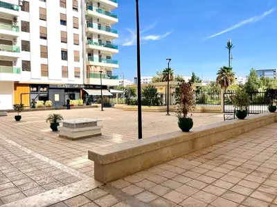 a courtyard with a bench and a building at Appartement luxueux Prestigia Wifi Fibre Optique in Fès