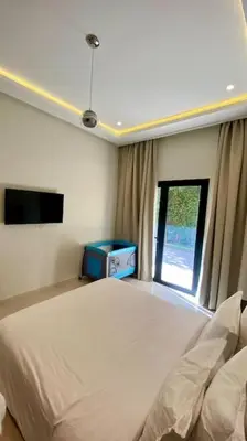 a white bedroom with a bed and a window at Villa P1 avec Piscine Chauffée in Marrakech