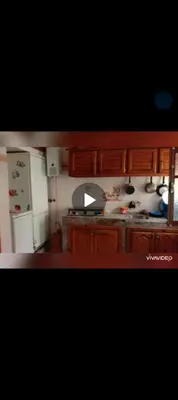 a kitchen with wooden cabinets and a white refrigerator at fes in Fès