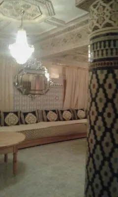 a living room with a couch and a chandelier at fes in Fès