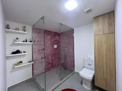 a bathroom with a glass shower with a toilet at Ghali Appart in Fès