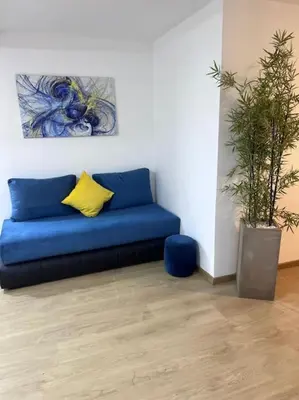 a blue couch in a room with a plant at Ghali Appart in Fès