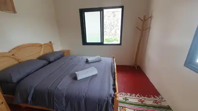 a bedroom with a bed and a window at Tayda Guest House in Azilal