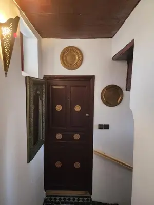 a wooden door in a room with a wall at Dar Zerbtana Chambre chaoune in Fès