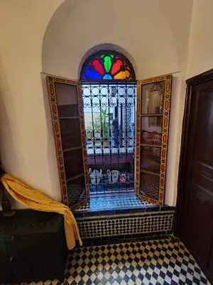 a stained glass window in a room with a tiled floor at Dar Zerbtana Chambre chaoune in Fès