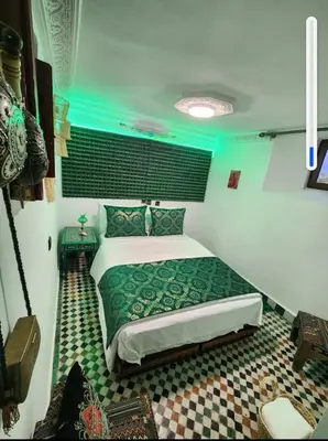 a bedroom with a bed in a room with blue lights at Dar Zarbtana Chambre Essaouira in Fès