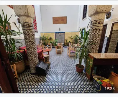 a room filled with potted plants and a room with tables at Dar Zarbtana Chambre Essaouira in Fès