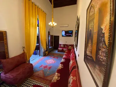 a living room with a couch and a mirror at Dar Zarbtana Chambre Essaouira in Fès