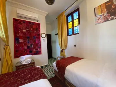 a hotel room with two beds and a window at Dar Zarbtana Chambre Hiba in Fès