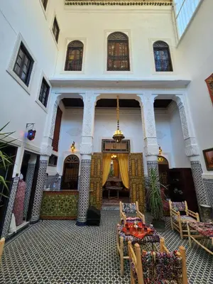 a room with tables and chairs in a building at Dar Zarbtana Chambre Hiba in Fès