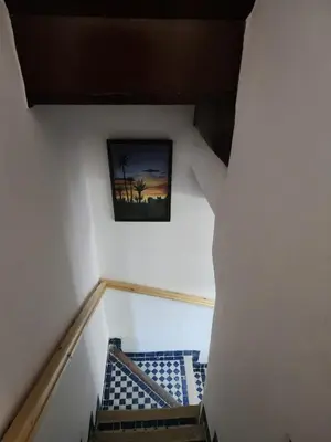 a stairway with a picture of a palm tree on the wall at Dar Zarbtana Chambre RADIA in Fès