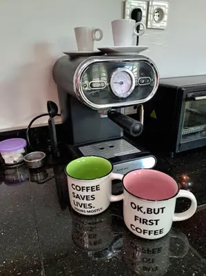 two coffee cups sitting on a counter next to a toaster at Appartement Jasmine Atlas Center in Fès