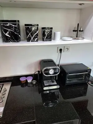 a kitchen with a counter with a toaster and a microwave at Appartement Jasmine Atlas Center in Fès