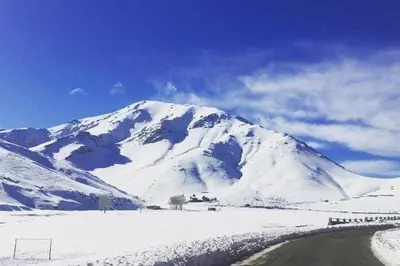 a snow covered mountain with a train in front of it at The Atlas View and Elegant Villa Marrakech in Marrakech