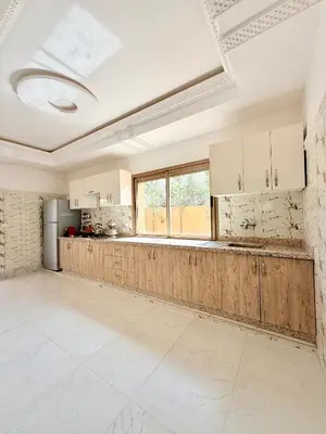 an empty kitchen with white cabinets and a window at The Atlas View and Elegant Villa Marrakech in Marrakech