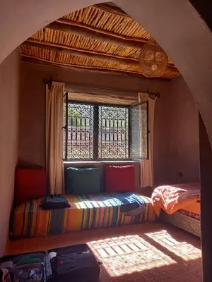 a bed in a room with a window at KASBAH Jardin des délices Timalizen in Tamzerdirt