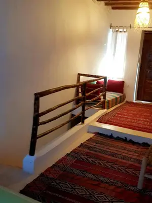 a room with a staircase with a bed and a rug at KASBAH Jardin des délices Timalizen in Tamzerdirt