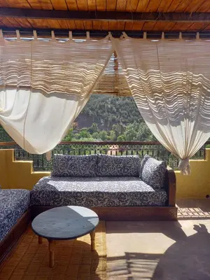 a living room with a couch and a table at KASBAH Jardin des délices Timalizen in Tamzerdirt
