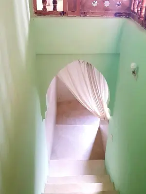 a hallway with a staircase with a pink curtain at KASBAH Jardin des délices Timalizen in Tamzerdirt