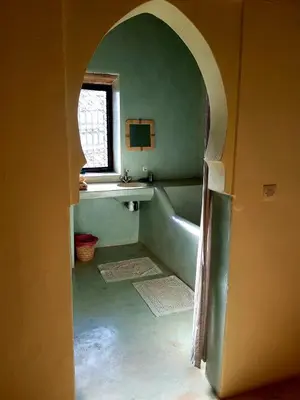 a bathroom with a tub and a sink and a window at KASBAH Jardin des délices Timalizen in Tamzerdirt