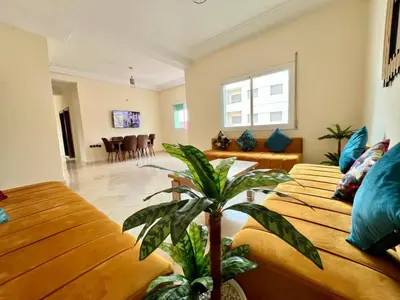 a living room with two couches and a plant at Appart Hotel Fes - Joud Families & Travelers in Fès