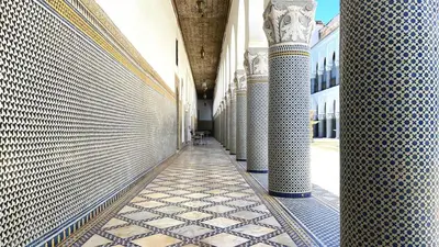 a hallway of a building with columns and tiled floors at Double room in Fès