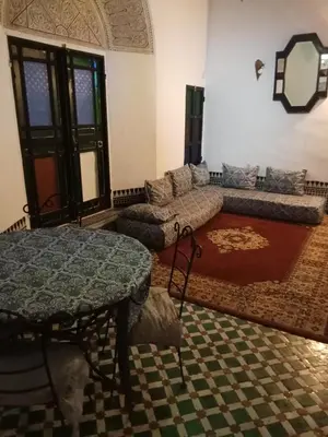 a living room with a couch and a table at Double room in Fès