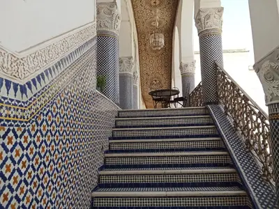 a staircase in a mosque with blue and white tiles at Double room in Fès