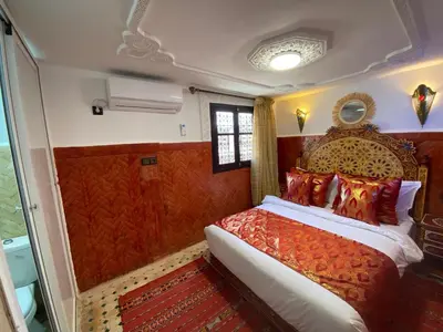 a bedroom with a large bed in a room at Dar Zarbtana Chambre Marrakech in Fès