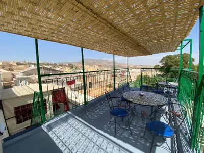 a balcony with a table and chairs and a view at Dar Zarbtana Chambre Marrakech in Fès