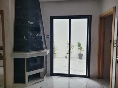 a living room with a door leading to a patio at Bella nova in Azrou