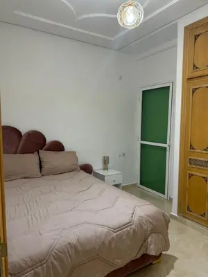 a bedroom with a bed and a green window at Mohammed zerrifi in Fès