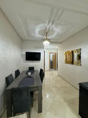 a dining room with a table and chairs and a television at Mohammed zerrifi in Fès