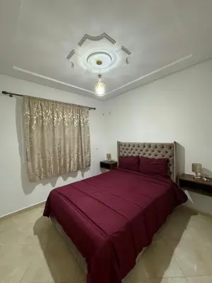 a bedroom with a large bed with a purple blanket at Mohammed zerrifi in Fès