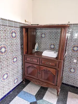 a wooden dresser in a room with tiles at Villa appartement jardin et piscine in Meknès