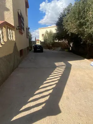 a shadow of a car parked next to a building at Villa appartement jardin et piscine in Meknès
