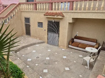 a patio with a door and a couch and a table at Villa appartement jardin et piscine in Meknès